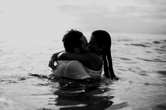 man-and-woman-kissing-together-on-body-of-water